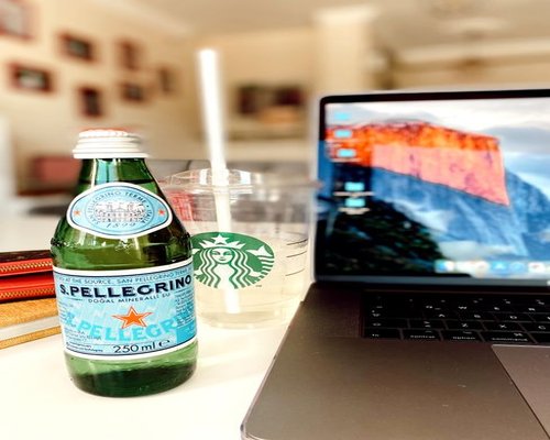 A workspace with a laptop next to a fresh glass of pure mineral water