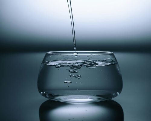 Clean drinking water being poured into a transparent glass for hydration tracking